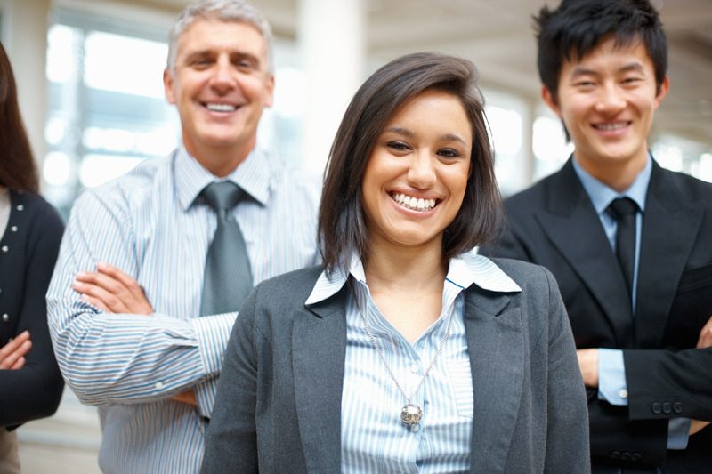 Smiling business woman standing in front of her team